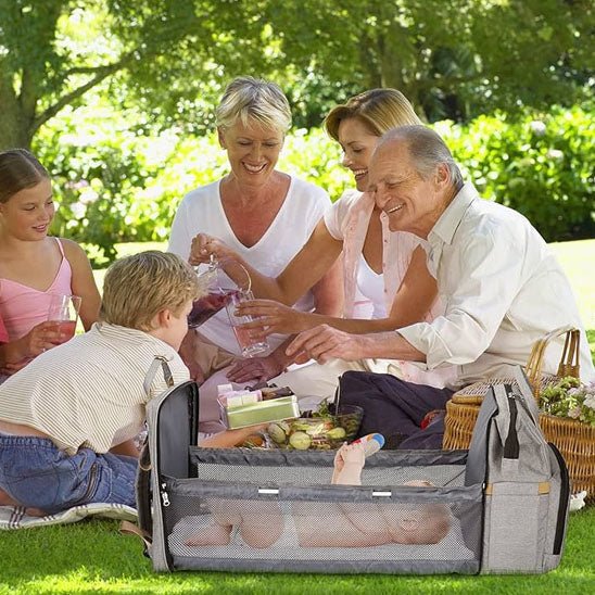 Famille en pique-nique avec leur sac à dos à langer lit.