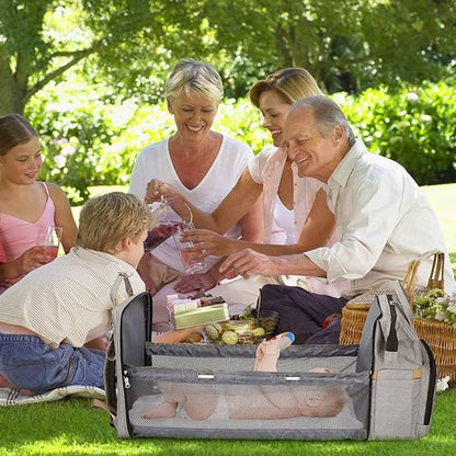 Famille en pique-nique avec leur sac à dos à langer lit.
