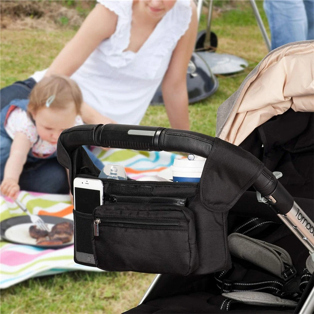 Famille piqueniquant et sac a langer bebe accroche sur poussette