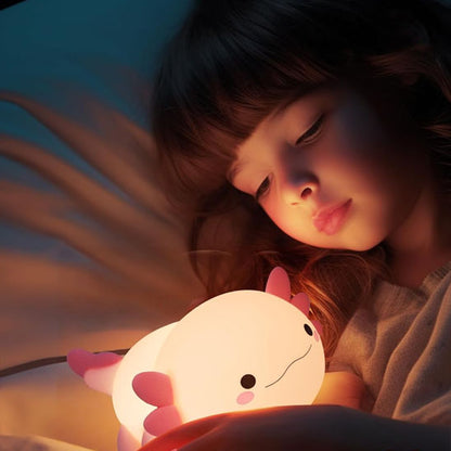 Fillette admirant sa veilleuse enfant axolotl rose