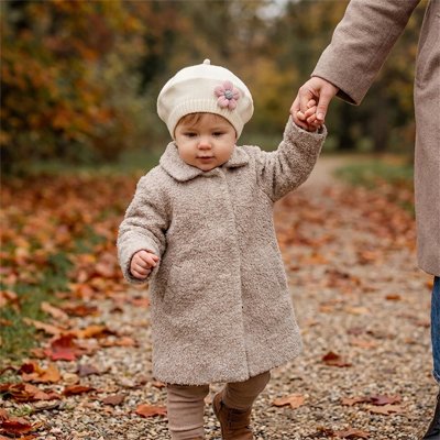 Fillette en promenade en automne avec son bonnet bebe blanc.