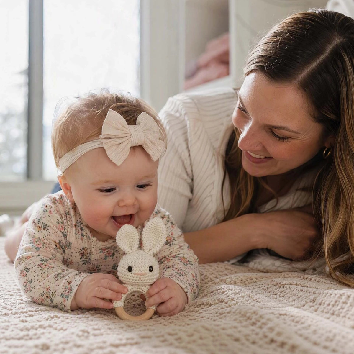 Fillette qui joue avec son petit hochet bébé lapin blanc.
