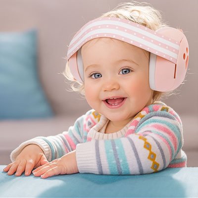 Fillette souriante portant son casque anti bruit bébé rose.