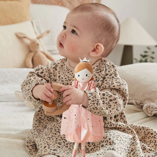 Fillette tient doudou bébé princesse dans ses bras