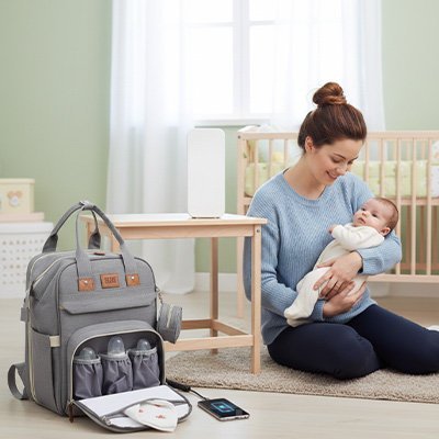 Maman et bébé dans la chambre avec sac à dos à langer bebe gris pâle.