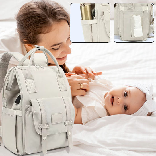 Maman câline bébé sur lit et sac à dos à langer