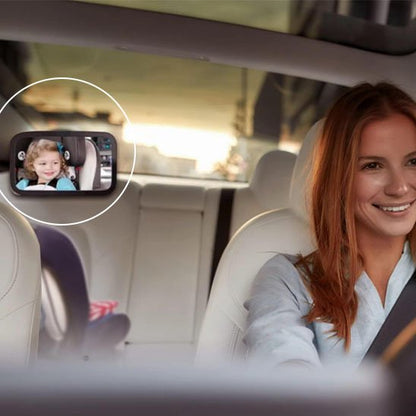 Maman dans la voiture garde un oeil sur bébé avec miroir voiture bébé. 