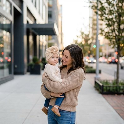 Maman en ville avec fillette portant un turban bebe fille beige.