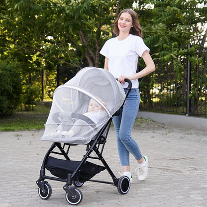 Maman et bébé au parc avec poussette et moustiquaire bebe