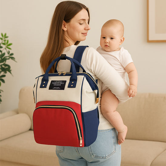 Maman portant bébé dans ses bras et sac à langer bebe tricolore