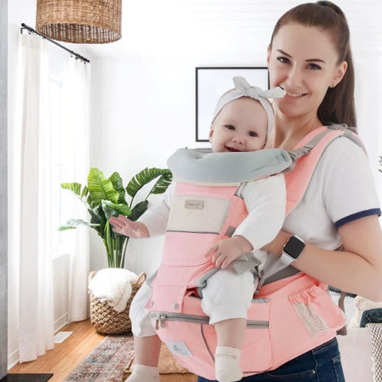 Maman portant bébé heureux dans porte bebe évolutif