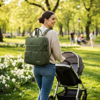 Maman avec son sac a dos a langer vert armé au parc.