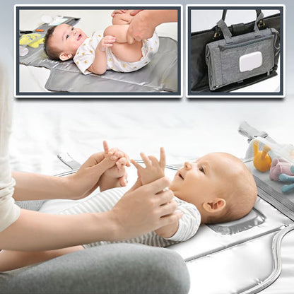 Maman tenant les mains de bébé sur tapis à langer nomade