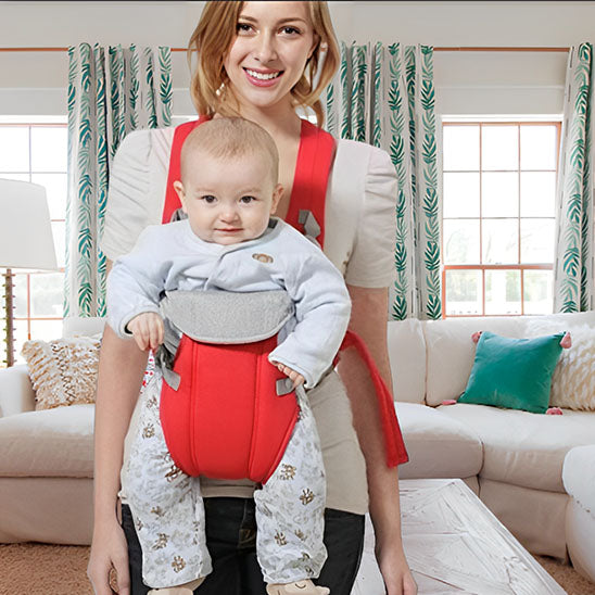 Maman utilisant porte bébé rouge à la maison