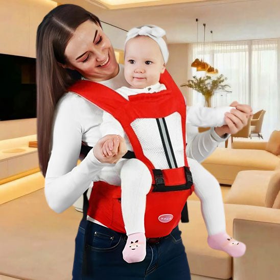 Mère et sa fille dans le salon avec un porte bébé physiologique rouge.