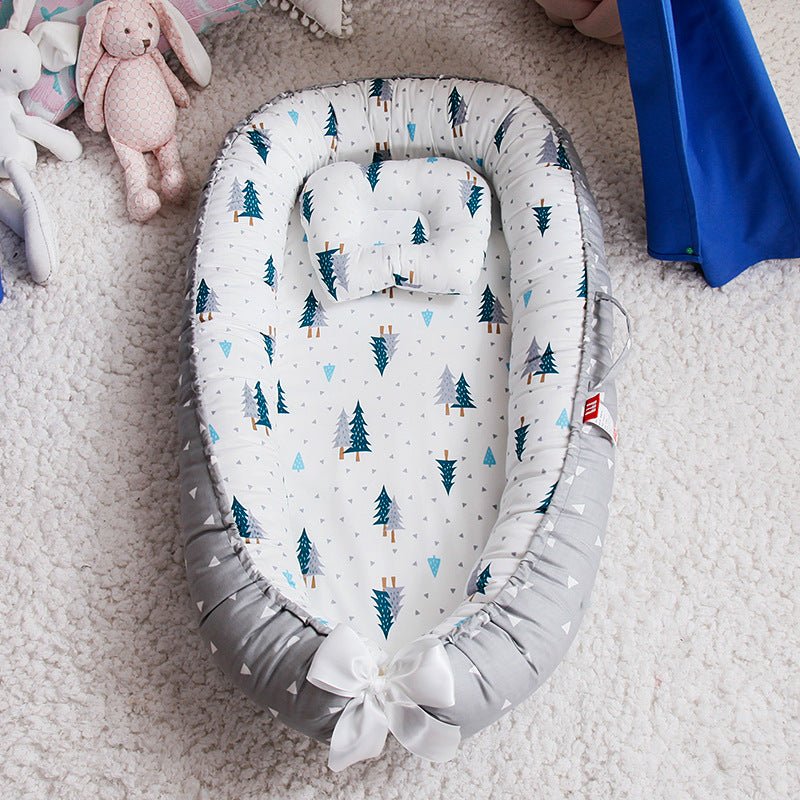Nid d Ange en coton avec jolis motifs de sapins.