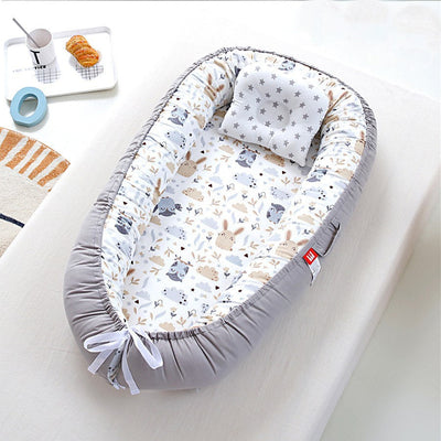 Nid d ange lit de voyage aux motifs hiboux et lapins gris et beige.