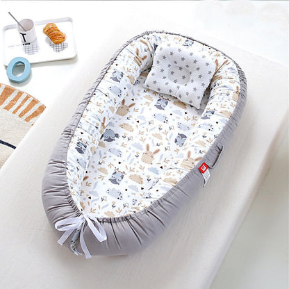 Nid d ange lit de voyage aux motifs hiboux et lapins gris et beige.