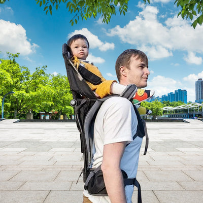 Papa en promenade avec bébé dans son porte bébé dorsal.