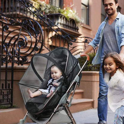 Papa en promenade avec poussette et moustiquaire bebe