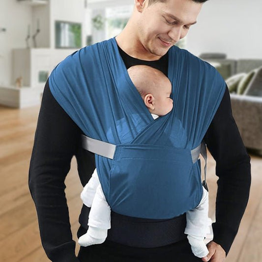 Papa portant son bébé avec son écharpe de portage bleue.