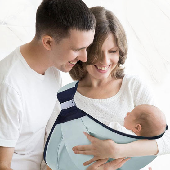 Parents heureux avec nouveau-né dans porte bebe coton