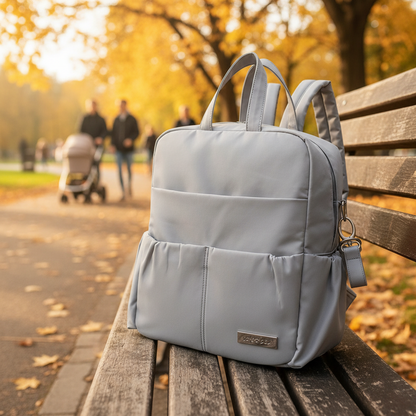 Sac a dos a langer gris sur un banc de parc en automne.