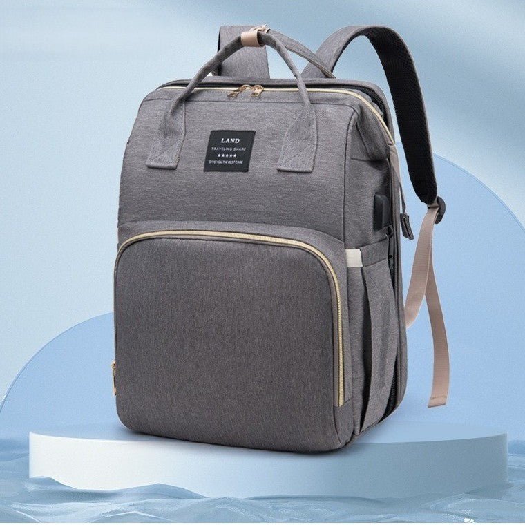 Sac à dos à langer gris sur socle bleu