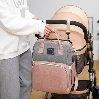 Sac à dos à langer suspendu à la poignée d'une poussette