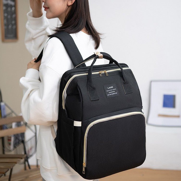 Maman portant sac à dos à langer noir pour balade