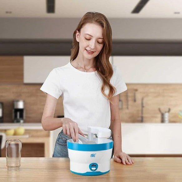 Maman dans la cuisine qui place biberons dans sterilisateur biberon